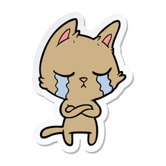sticker of a crying cartoon cat with folded arms