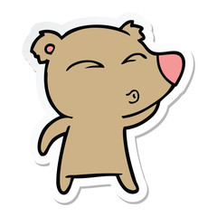 sticker of a cartoon whistling bear