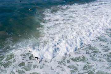 Fototapeta na wymiar Aerial view of a number of surfers at famous Bell's beach in Victoria, Australia