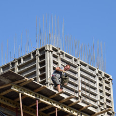 Worker pouring cement. Construction of a multistory building