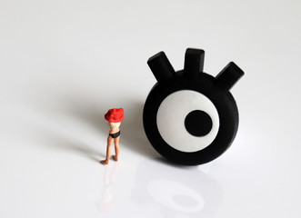 The concept of sneaking into a woman's private life. Eye and a miniature woman who is changing clothes.