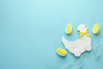 Easter holiday creative background with papercraft eggs, white wooden chicken hun on pastel blue table, trendy paper craft holiday background, top view, copy space