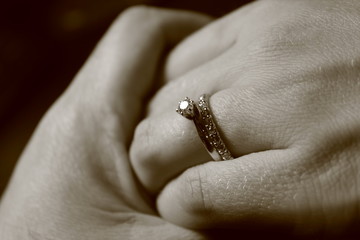 hands with wedding rings on a black background
