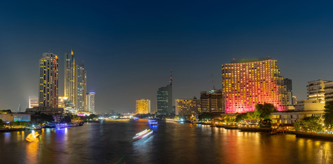 Cityscape riverfront with long exposure light on the bridge. Bangkok, Thailand. Panorama