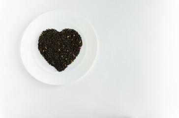 flower tea on a white plate in the shape of a heart a white background