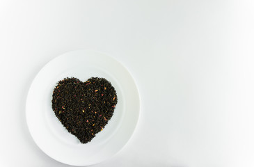 flower tea on a white plate in the shape of a heart a white background