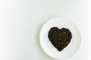 flower tea on a white plate in the shape of a heart a white background