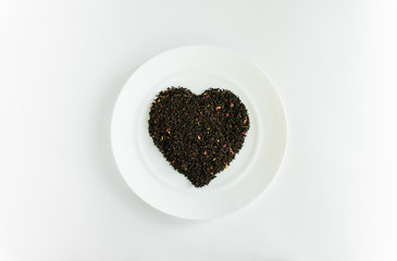 flower tea on a white plate in the shape of a heart a white background