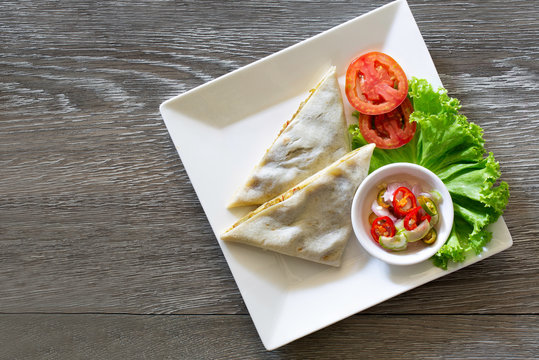 Roti mataba and in white dish on wooden table Muslim food, Halal food and vegetable pickled sauce in cup on wooden chopping board
