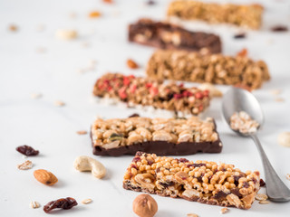 Granola bar with copy space. Set of different granola bars on white marble table. Shallow DOF.