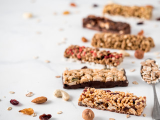 Granola bar with copy space. Set of different granola bars on white marble table. Shallow DOF.