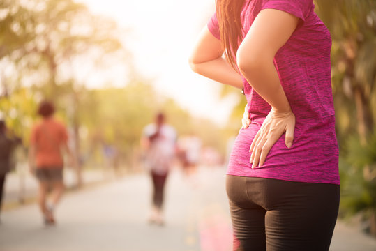 Young Asian Woman Feel Pain On Her Back And Hip While Exercising, Health Care Concept.