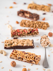 Granola bar with copy space. Set of different granola bars on white marble table. Shallow DOF. Vertical.