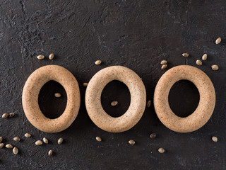 Ring-shaped cracknel with whole grain hemp seed flour and hemp seeds on black background. ring-shaped cracknel close up. Copy space Top view or flat lay.