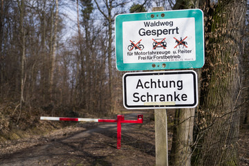 Schild vor Waldweg gesperrt mit einer Schranke