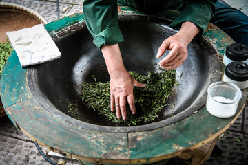 Traditional tea making Drying green tea in pan processing by hand at Longjing Village in Hangzhou...
