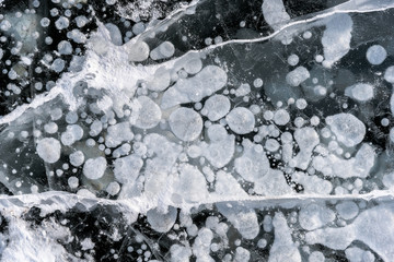 Background frozen gas bubbles in the frozen ice of the lake and river in winter