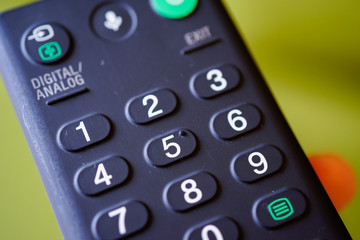 Man holding tv remote commander and number channel