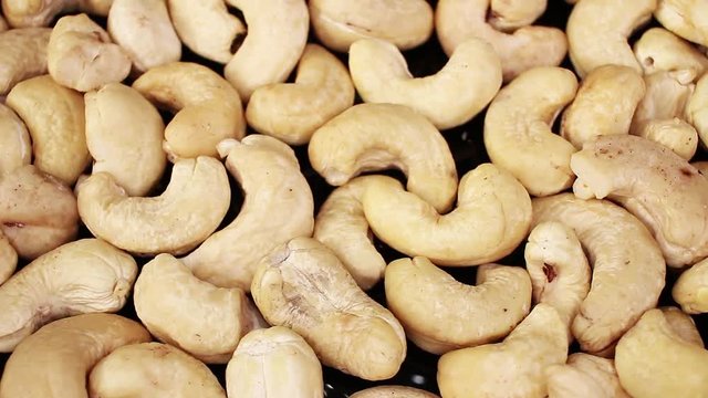 Cashew nuts closeup texture video on rolling rotating looping plate