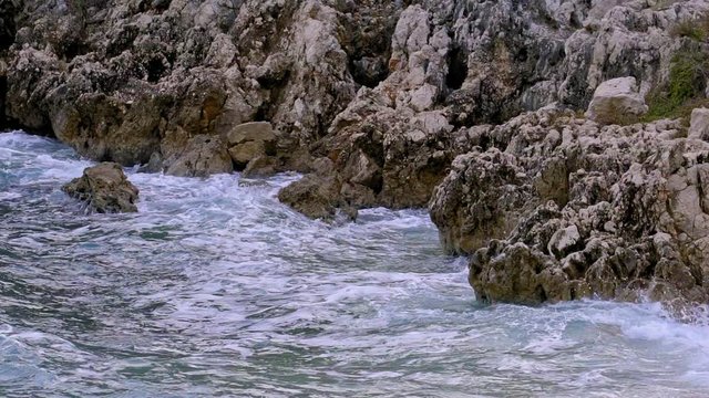 Beautiful close up of the rocky coast of Brestova and the motion of the waves. Croatia. Flat plane. Slow motion