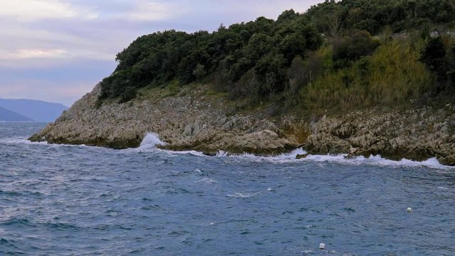 Beautiful detail of Brestova rocky coast and vegetation on a cloudy day. Croatia. Flat plane. Slow motion