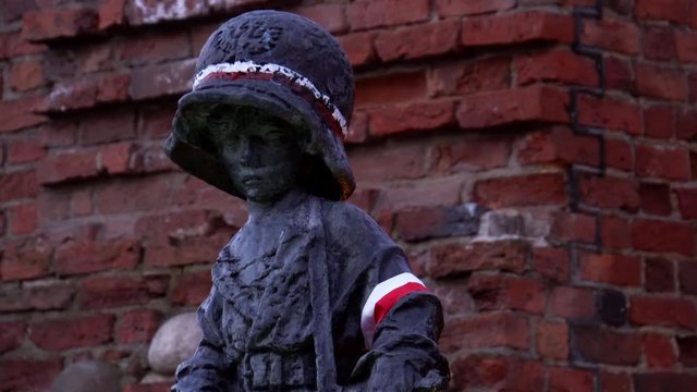 Innocent emotional Maly Powstaniec child insurgent soldier statue of bronze material in old Warsaw town
(close up shot)