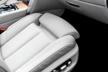 White leather interior of the luxury modern car. Perforated white leather comfortable seats with stitching.  Modern car interior details. Car detailing. Car inside