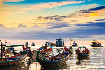 Fototapeta na wymiar Amazing colorful sunset sky with silhouette wooden boat on sea coastline