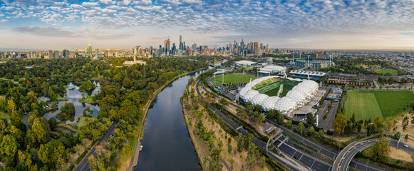 Naklejka premium Panoramiczny widok z lotu ptaka na stadion MCG i AAMI z CBD w tle