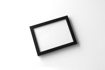 blank black picture frame on white table background. top view