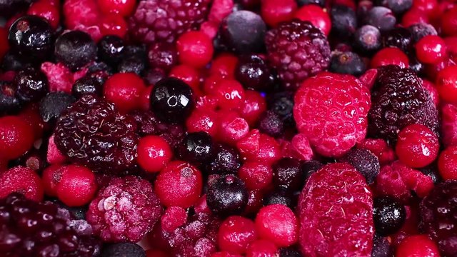 Berry fruit mix blueberry blackberry mulberry closeup texture video on rolling rotating looping plate