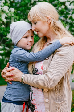 blond happy young grandma hugging child of five years