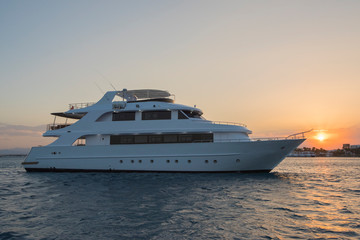 Luxury private motor yacht on tropcial sea at sunset
