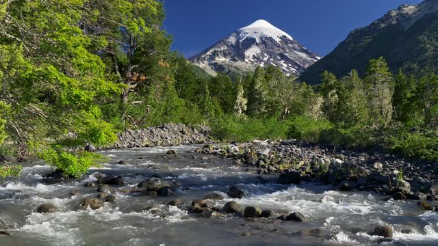 Water flowing through a mountain stream. Lanin volcano is seen in the background. Southern Andes, Argentina near the Chilean border. 4K