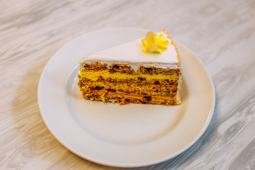 beautiful biscuit piece of cake with nuts, fruit, cream and protein cream on the table