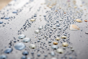 macro drops with colorful iridescence dark surface