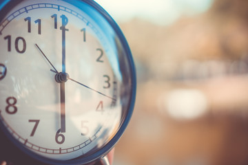 Selective focus of alarm clock with nature background.