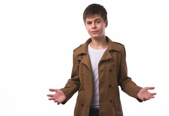 Portrait of surprised teen boy with divorced raised hands isolated on white background. A boy with a surprised face looks straight into the camera.