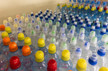 Lid plastic water bottle in the market. multi-colored plastic bottle caps	
