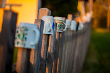 Ceramic coffee and tea mugs and cups on the fence,  garden decoration/ Bohemian paradise, Czech Republic