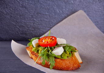 Sliced Toast Bread with tomatoes, feta and arugula on the paper