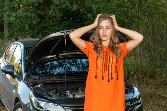 Pretty, young woman by the roadside after her car has broken down - Image
