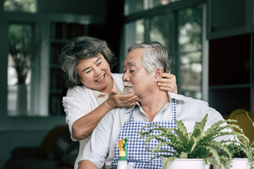 Obraz premium Elderly couples talking together and plant a trees in pots.