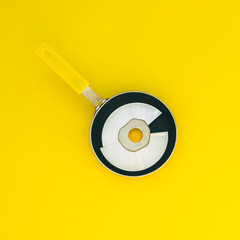 mirror disk is fried in a pan on a yellow background.  flat lay