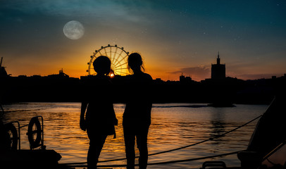 silhouettes of two young girls at sunset