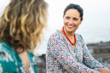 Two mid-aged women talking and relaxing outdoor
