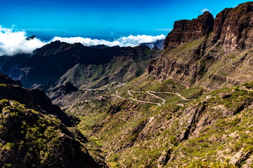 Fototapeta na wymiar Tenerife, Canary Islands, Spain - The winding mountain road, the mountainous landscape inland on the coast in the west, on the island of Tenerife, on a sunny day in October.