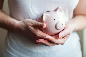 Obraz na płótnie Canvas Female woman hands holding pink piggy bank. Saving investment budget business wealth retirement financial money banking concept