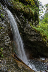 Fototapeta na wymiar fast mountain rocky river in forest with waterfall