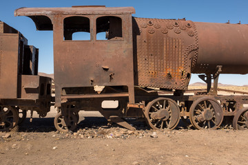 Fototapeta na wymiar Side view of a rusting steam train as it slowly rots away at the train graveyard just outside of Uyuni, Bolivia